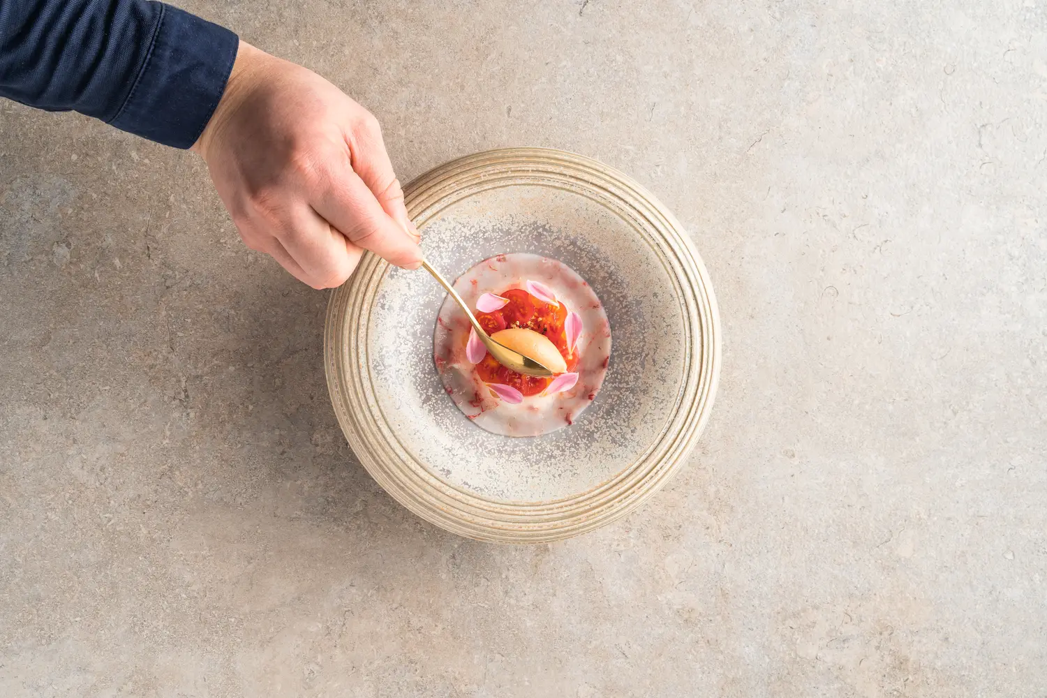 Sorbet wordt met een gouden lepel op het gerecht gelegd