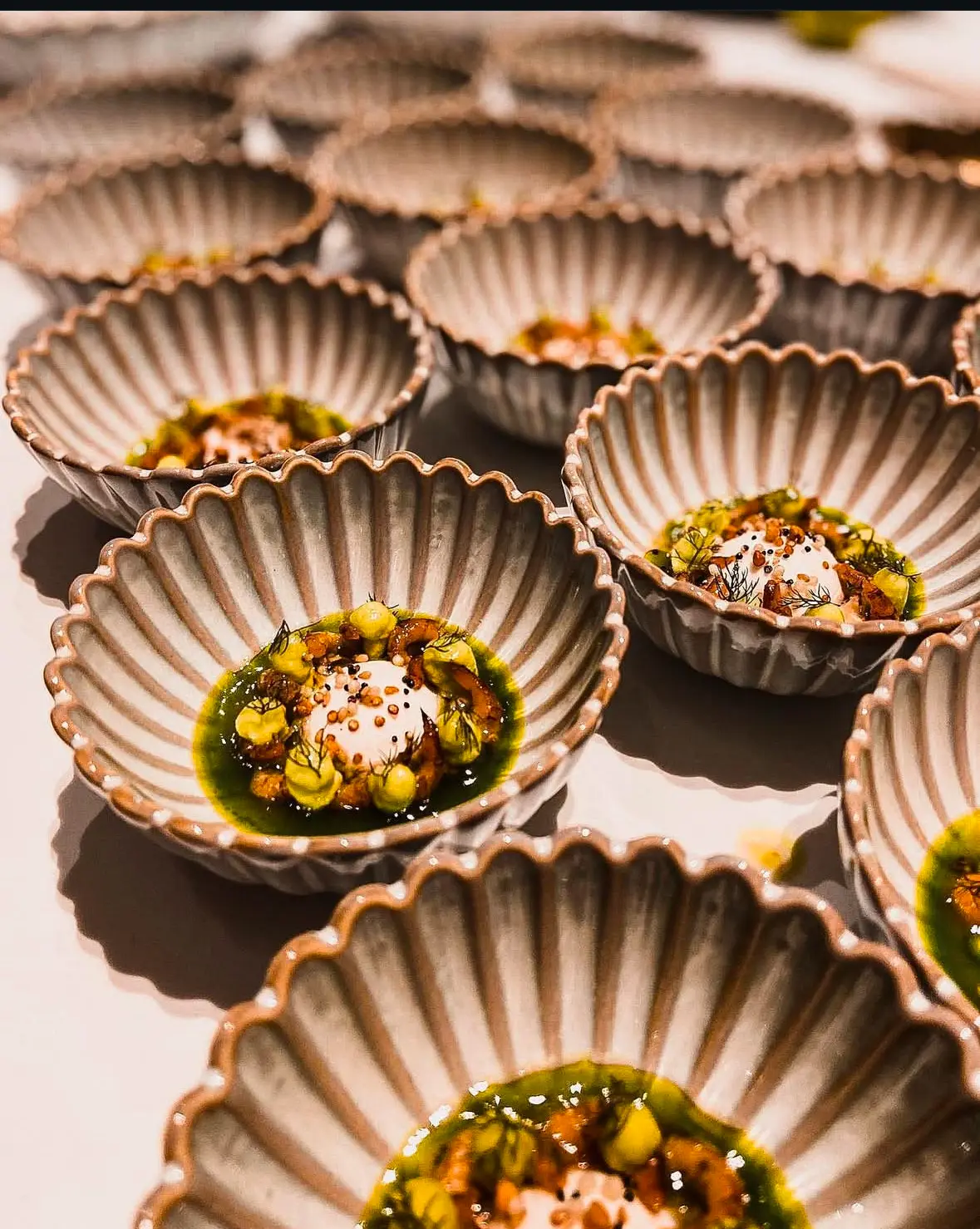 Gerecht in een turquoise kom met gouden lepels